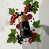 Szklana butelka serum porzeczkowego z heksapeptydem Orcideo w otoczeniu świeżych owoców czarnej i czerwonej porzeczki na jasnym tle